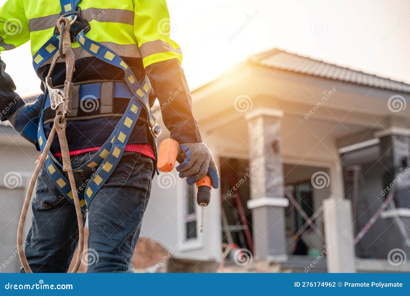 A Roofer Wearing Safety Harness Belt Stands Holding an Air Gun or