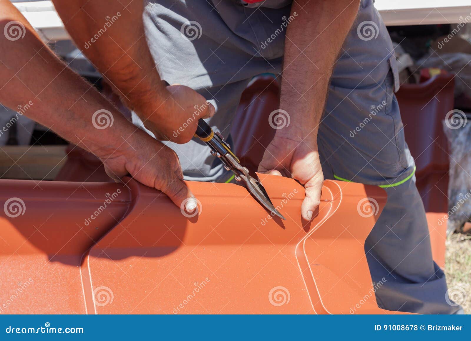 Roofers Cut a Metal Tile Using Cutting Pliers. Stock Photo Image of