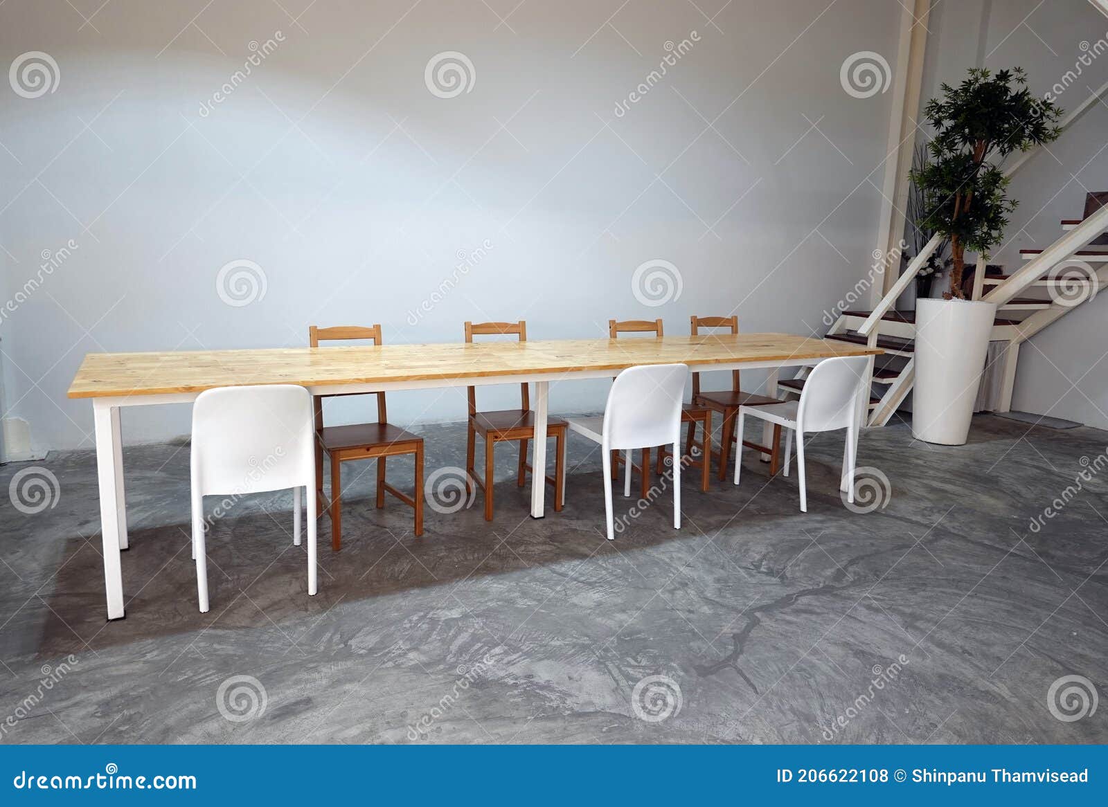 Room with Wood Long Dining Table and White Chairs. Stock Photo Image