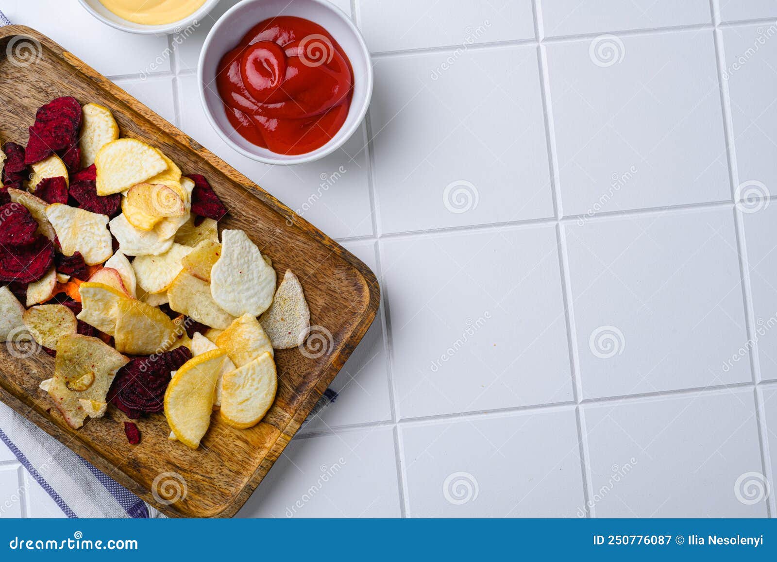 Root Vegetable Crisps, on White Ceramic Squared Tile Table Background