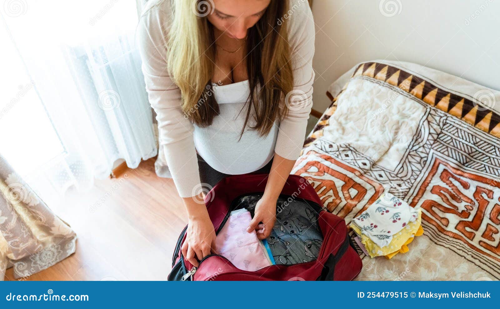 Ropa De Bebé. Embarazo Joven Feliz Madre Sosteniendo Ropa De Bebé Amarilla.  Mujer Embarazada Que Empaca La Maleta Imagen de archivo - Imagen de cama,  maternidad: 254479515