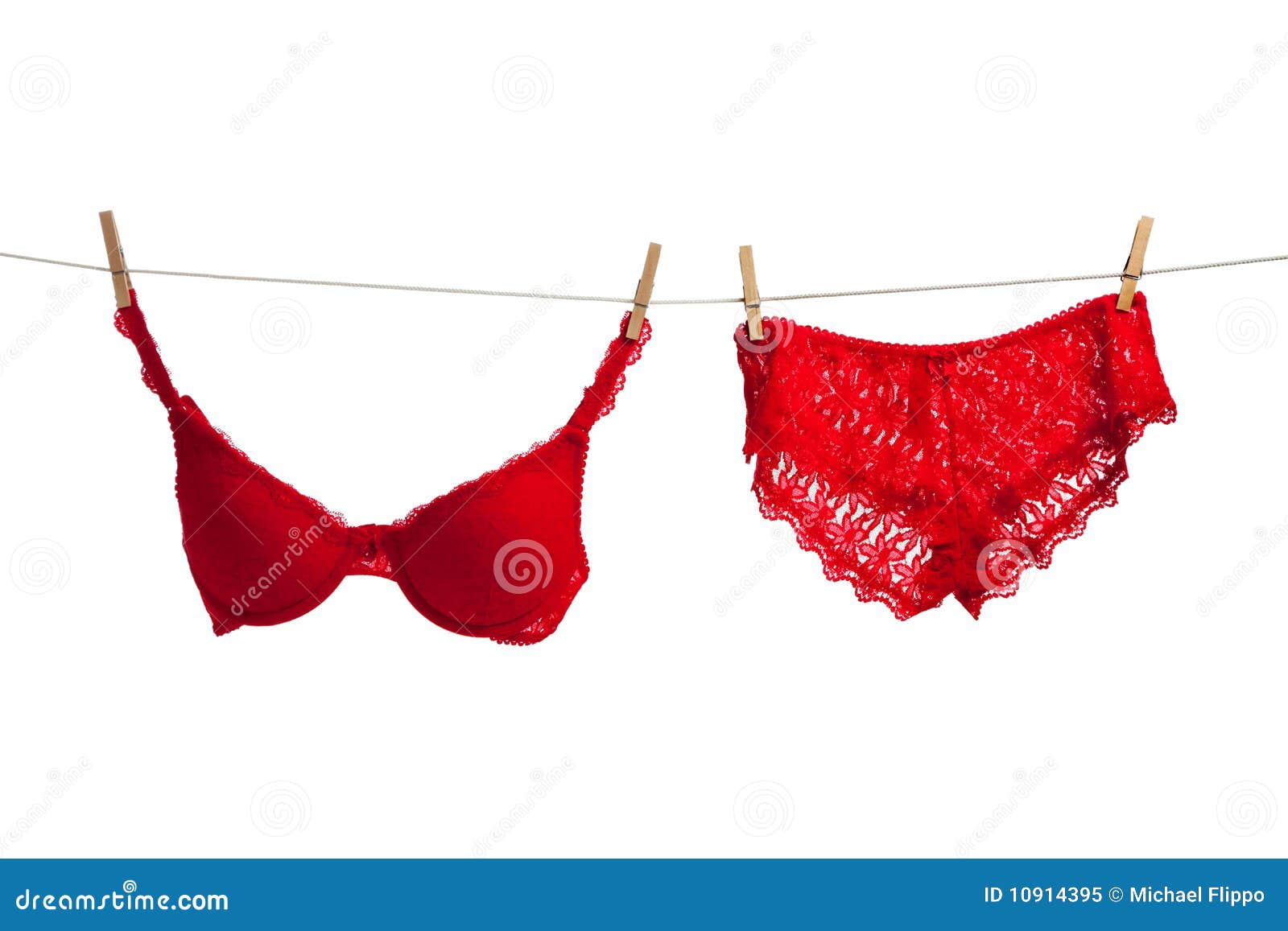 Una ropa interior roja atractiva en una cuerda para tender la ropa en un fondo blanco - día del sujetador y de las bragas de tarjeta del día de San Valentín