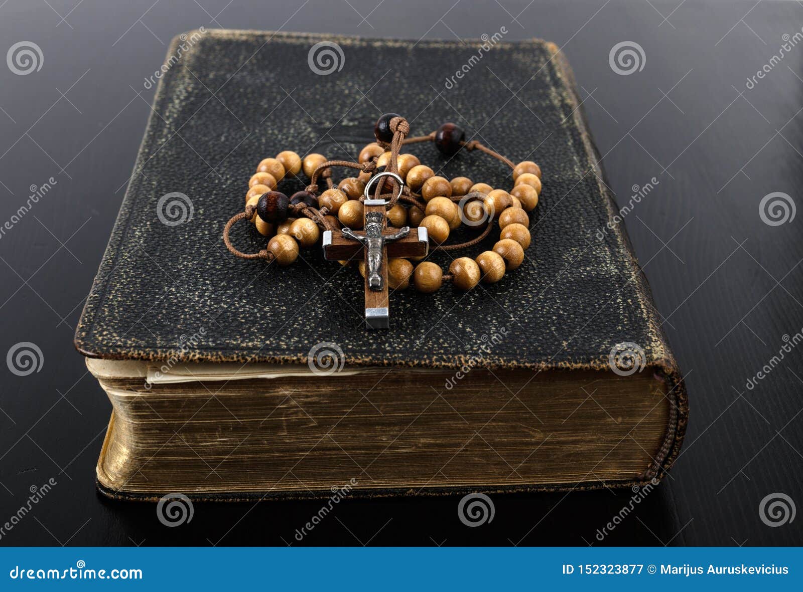 rosary beads and prayer book on dark background
