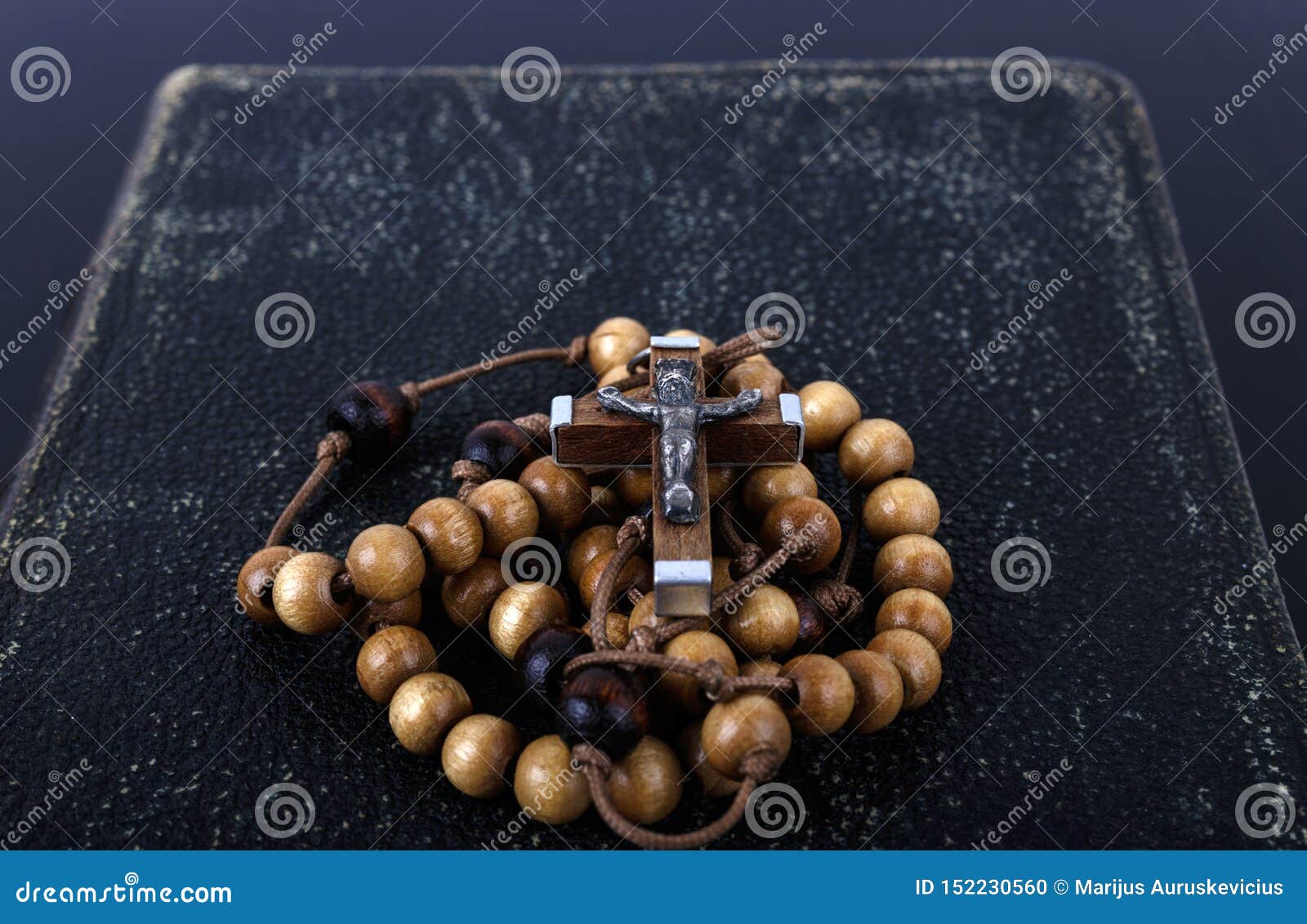 rosary beads and prayer book on dark background