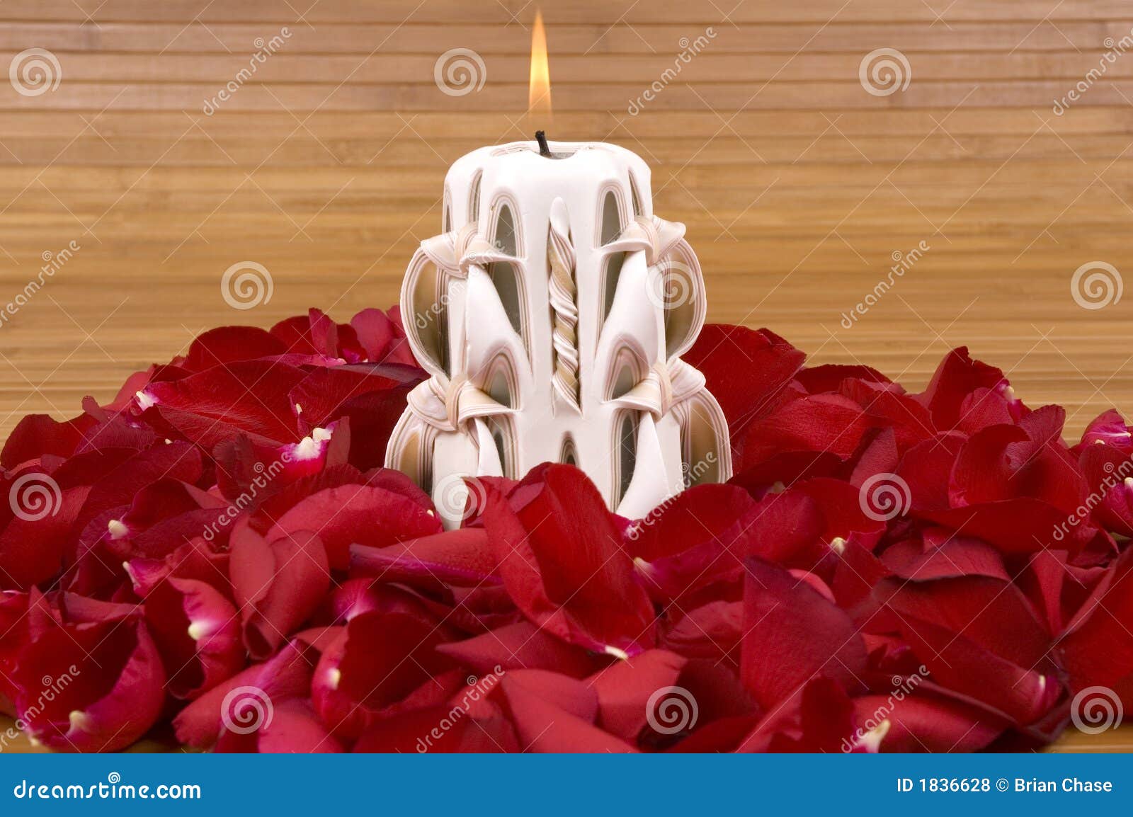 Fragrant candle and hundreds of romantic red rose petals