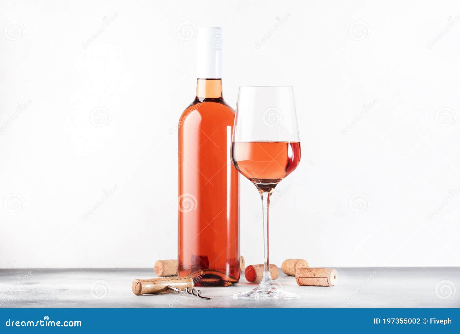 rose wine glass with bottle on the gray table. pink rosado, rosato or blush wine tasting in wineshop, bar concept. copy space