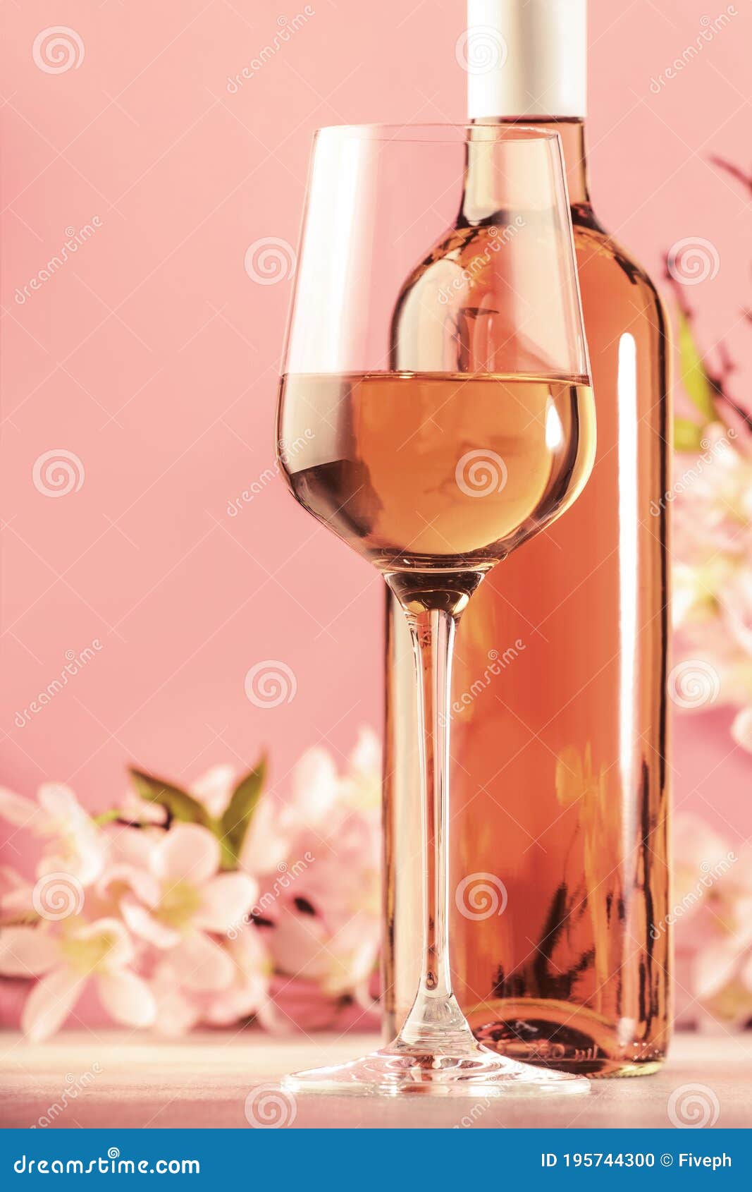 rose wine glass with bottle and pink flowers. rosado, rosato or blush wine tasting in wineshop, bar concept. copy space