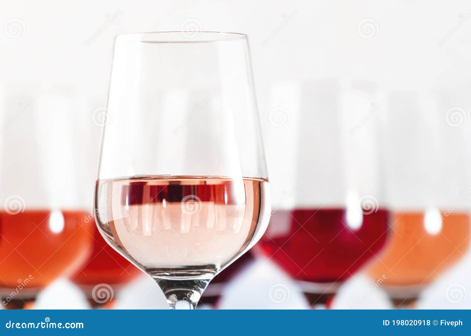 rose wine glasses set on wine tasting. tasting different varieties, colors and shades of pink wine concept. white background