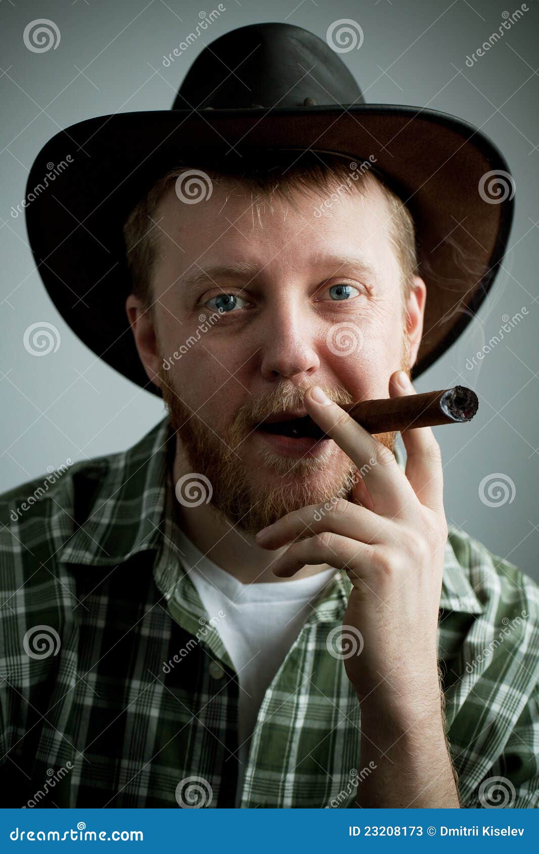Rot-bärtiger Mann in einem Cowboyhut und in einem Hemd mit einer Zigarre in seinem Mund
