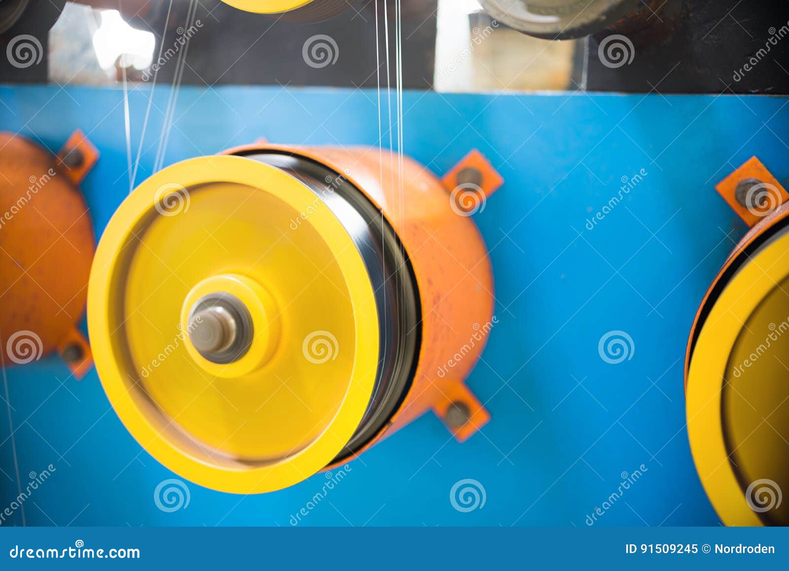 A Rotating Wheel Rewinds a Thin Silver Wire. Stock Image Image of