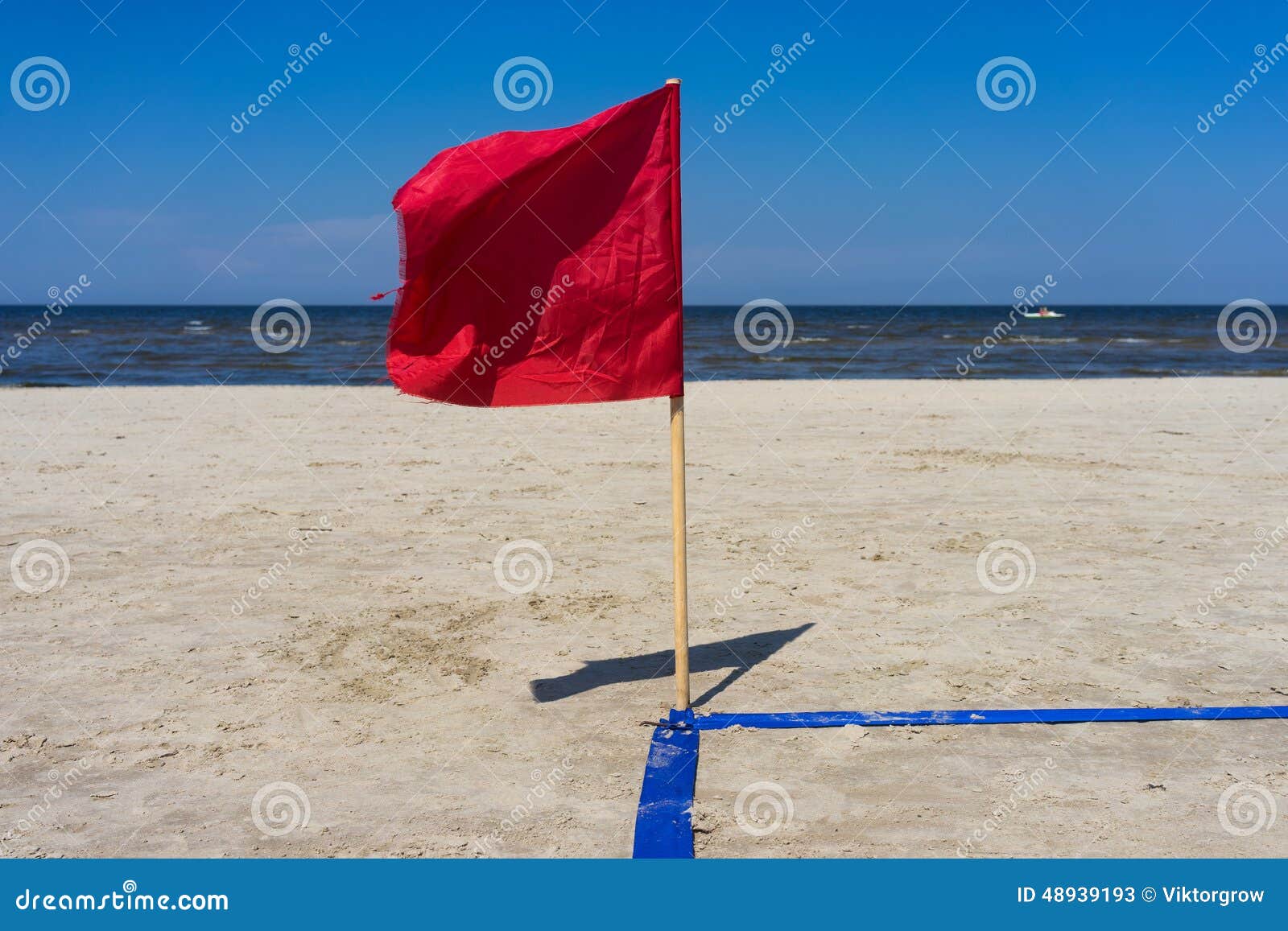 Rote Fahne Im Wind Auf Dem Sandigen Strand Stockbild - Bild von