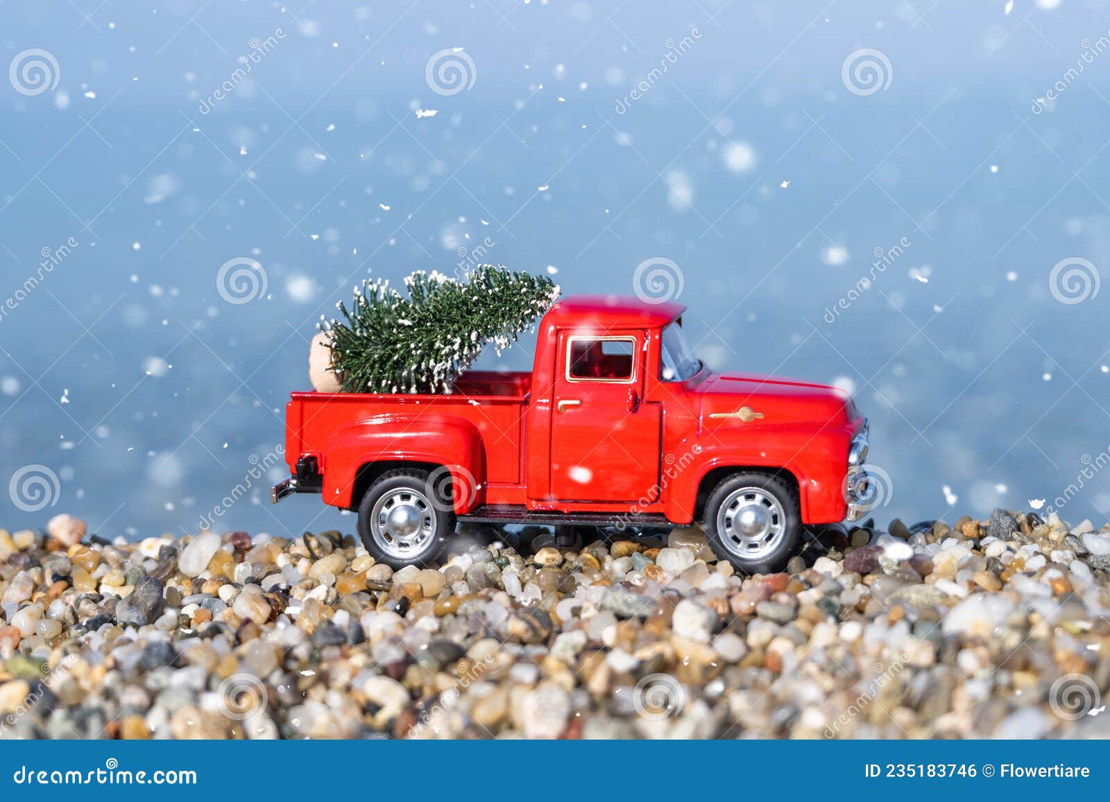 Roter Retro Kleinwagen Mit Weihnachtsbaum am Strand Im Schneefall 