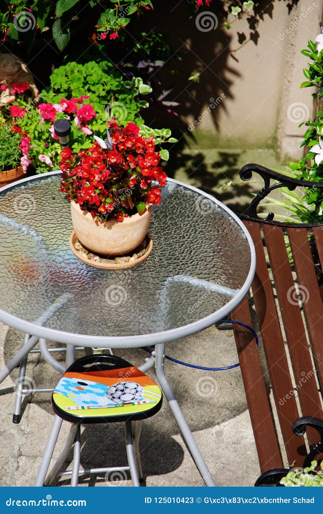 Round Garden Table With Glass Top And Flower Pot Stock Image