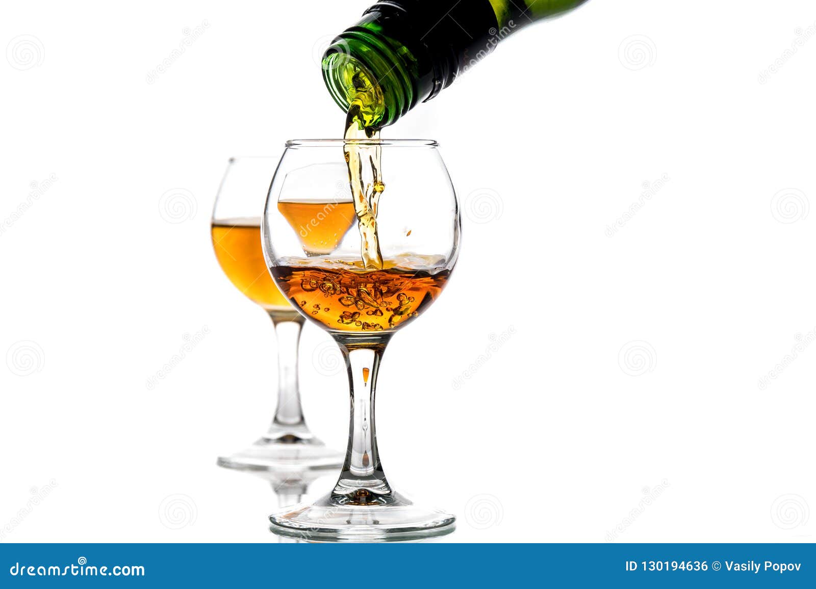 A Round Glass with Brandy and a Splash of Drink Inside Stock Photo