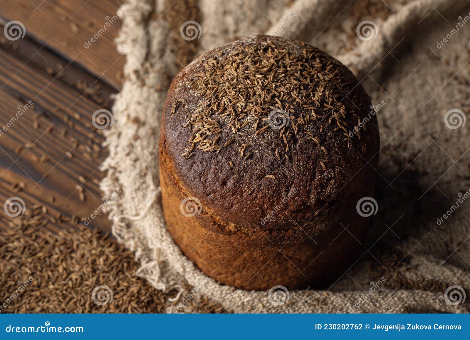 Round Loaf of Rye Bread with Thyme on Rustic Style Wooden Table. Stock
