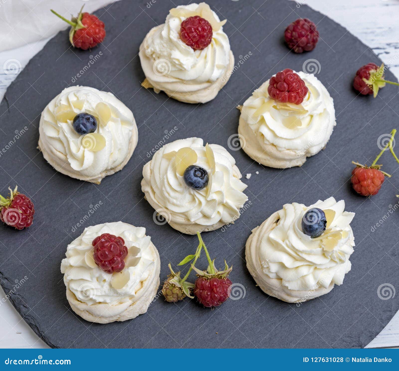 Round Meringues with Whipped Cream on a Black Graphite Board Stock
