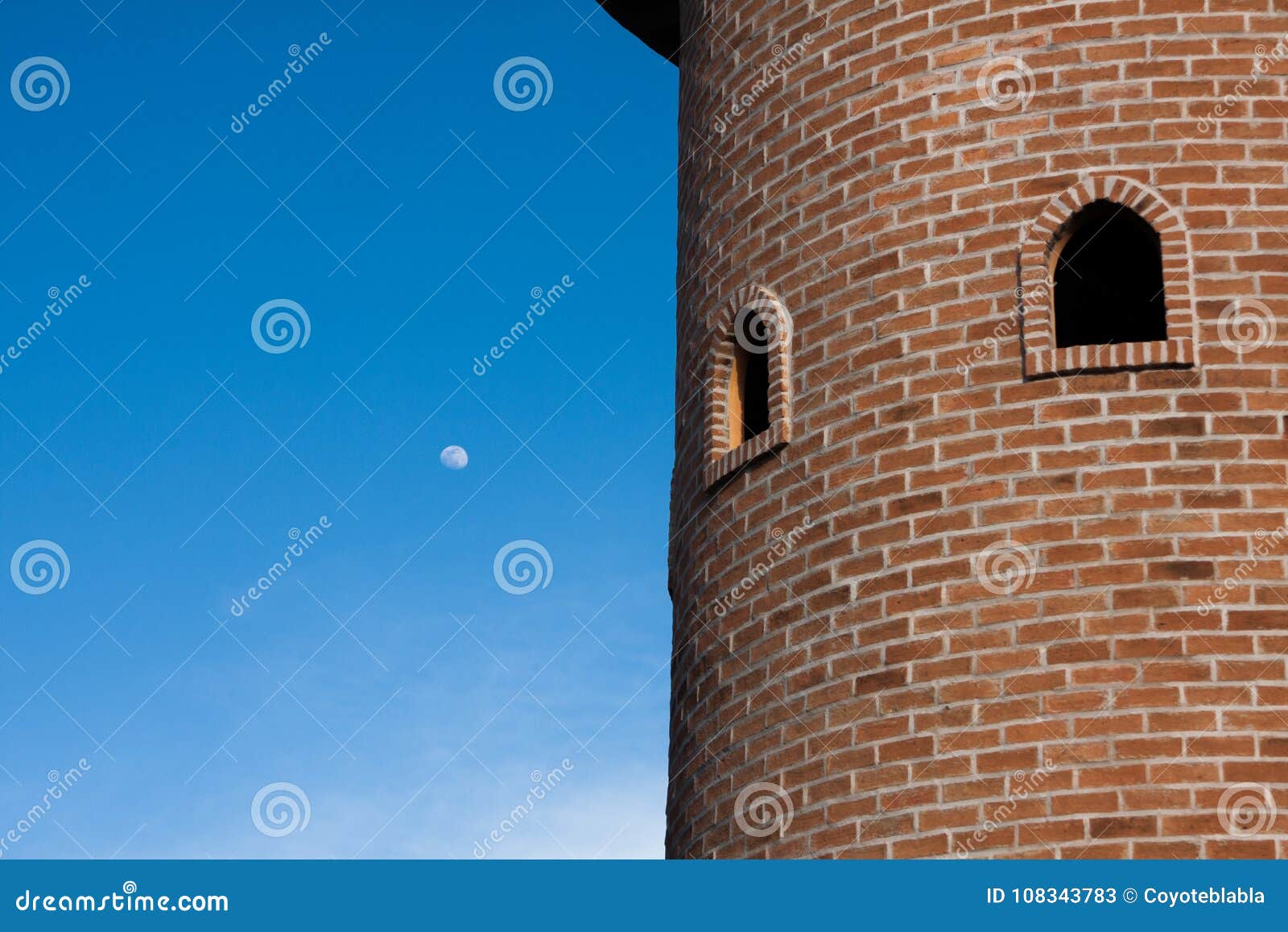 Round Red Brick Block Tower with Round Window in Blue Clear Sky Stock