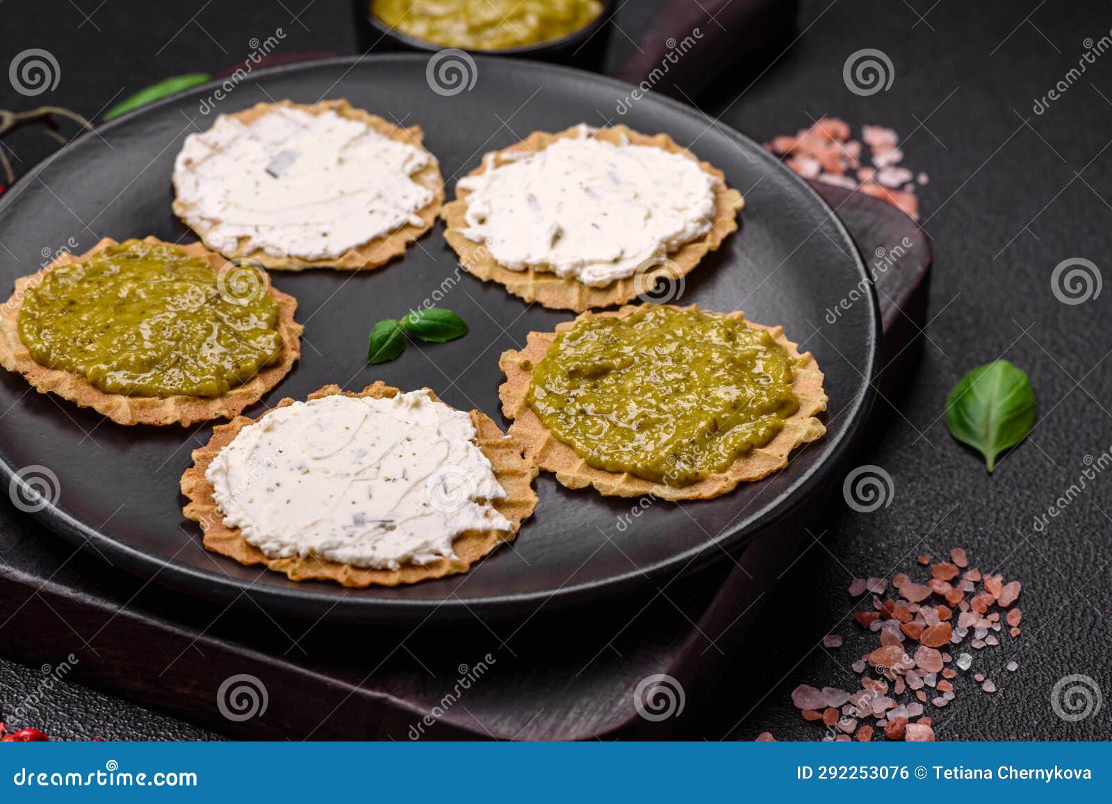 Round Snacks with Crispy Chips or Crackers with Cream Cheese and Pesto