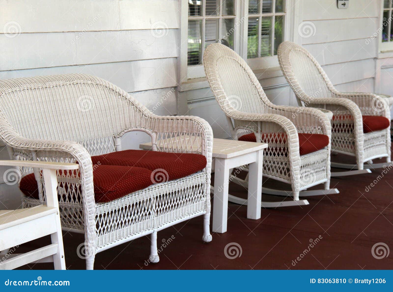 Row Of Comfy Wicker Chairs On Rustic Front Porch Stock Photo
