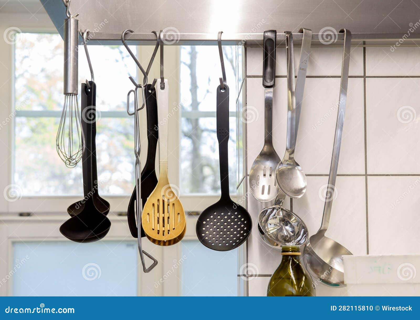 row of decorative spats suspended from the ceiling in a kitchen setting.