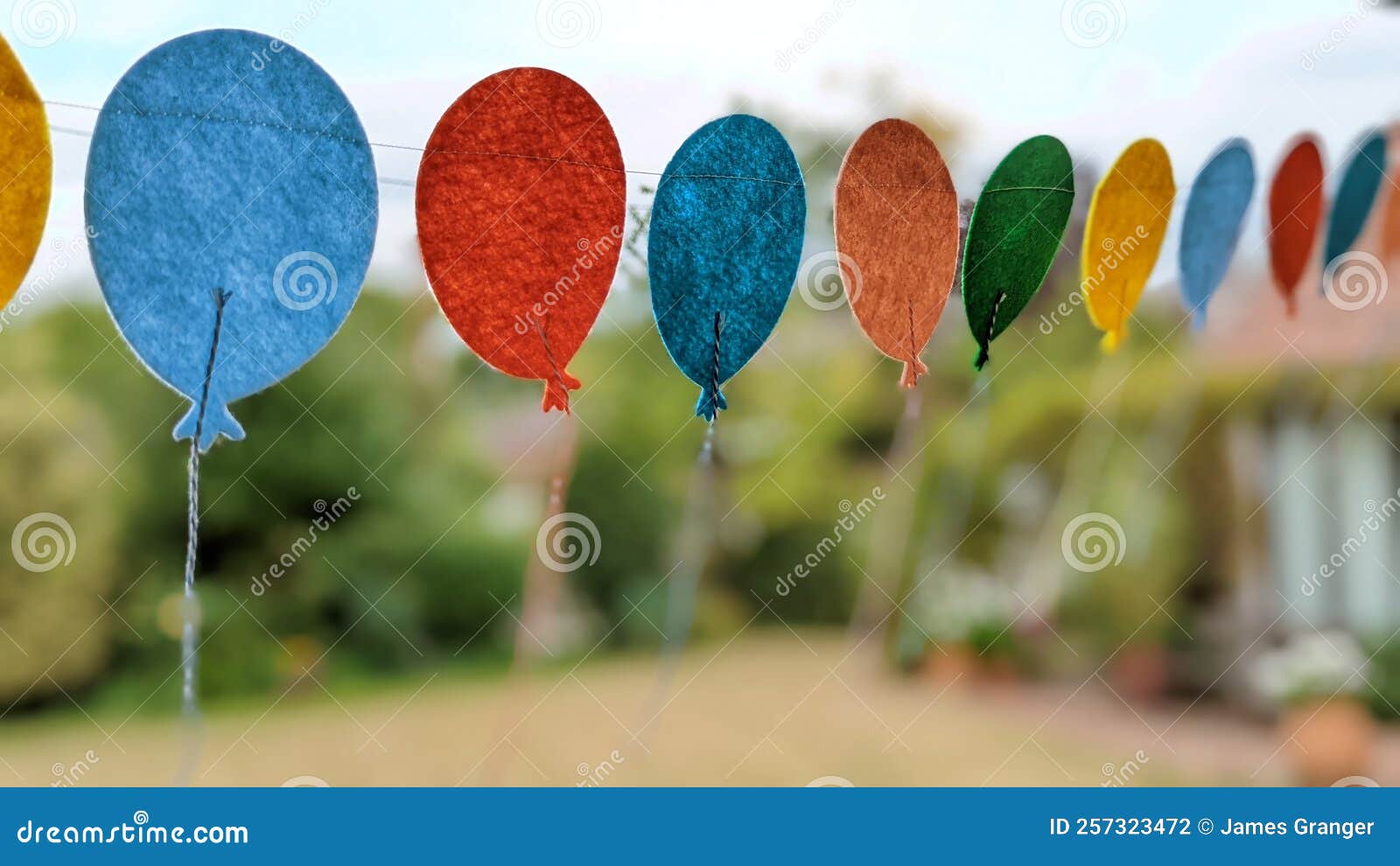 A Row of Felt Balloons Hanging on a String in the Garden Stock Photo -  Image of petal, garden: 257323472