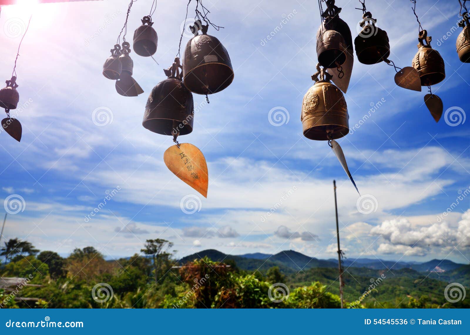 row of golden bells in buddhist temple. background of mountains in asia, tailandia