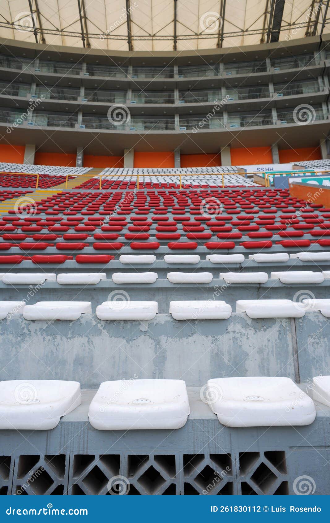 rows of empty orange and white seats in the sports complex of the estadio nacional - soccer stadium - in lima peru