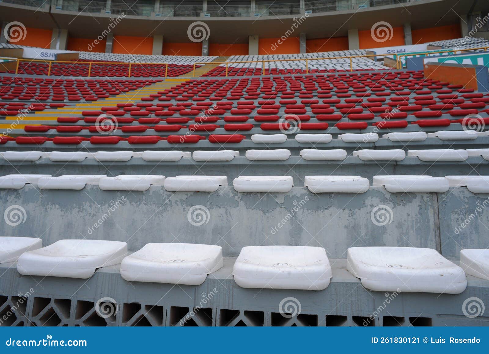 rows of empty orange and white seats in the sports complex of the estadio nacional - soccer stadium - in lima peru