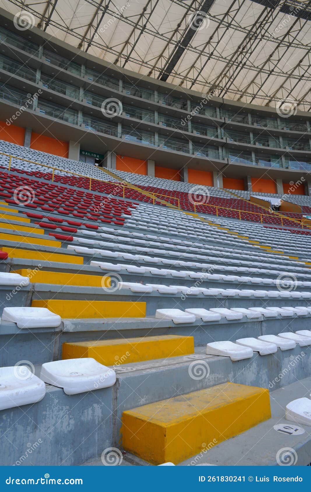 rows of empty orange and white seats in the sports complex of the estadio nacional - soccer stadium - in lima peru