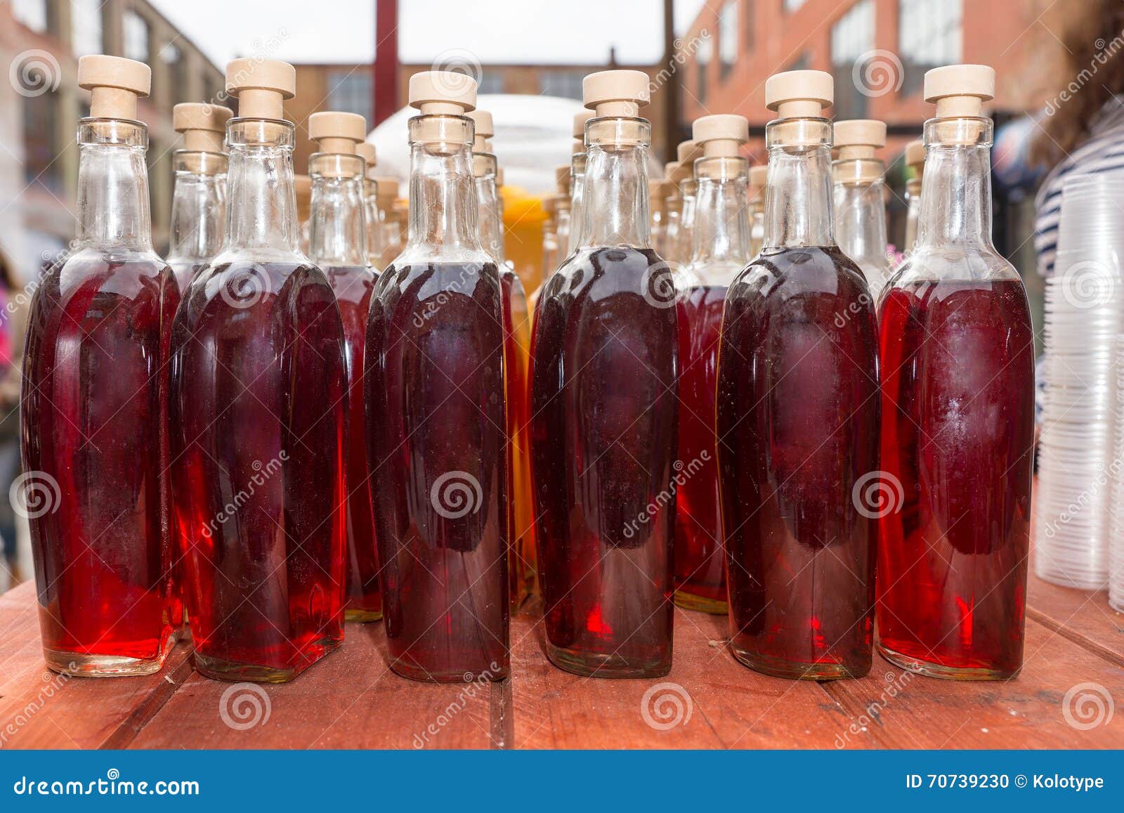 Rows of Gourmet Soda in Corked Bottles. Close Up Still Life of Corked Bottles Containing Homemade Gourmet Red Soda Arranged Neatly in Rows on Table at Outdoor Food Festival