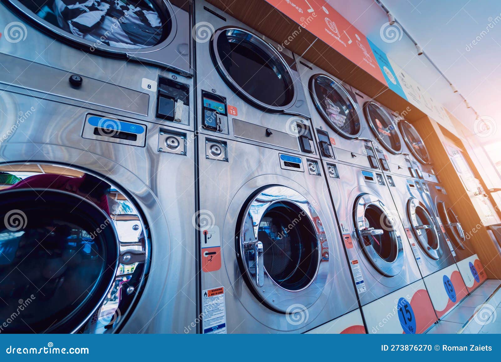 Rows of Industrial Laundry Machines in the Large Laundromat. Stock