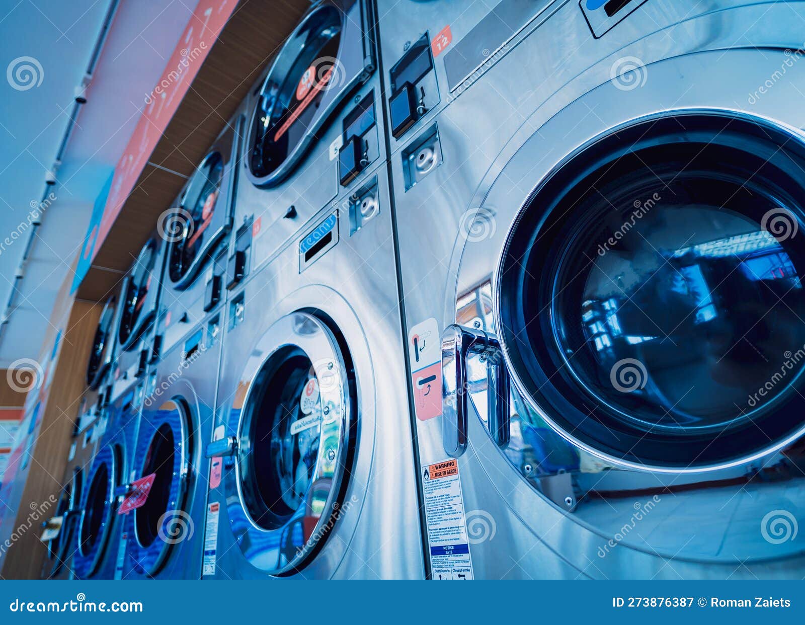 Rows of Industrial Laundry Machines in the Large Laundromat. Stock