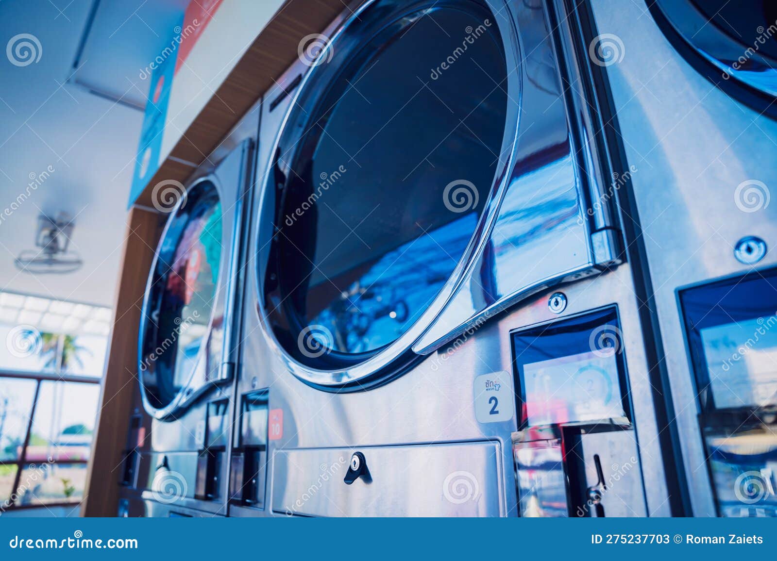 Rows of Industrial Laundry Machines in the Large Laundromat. Stock