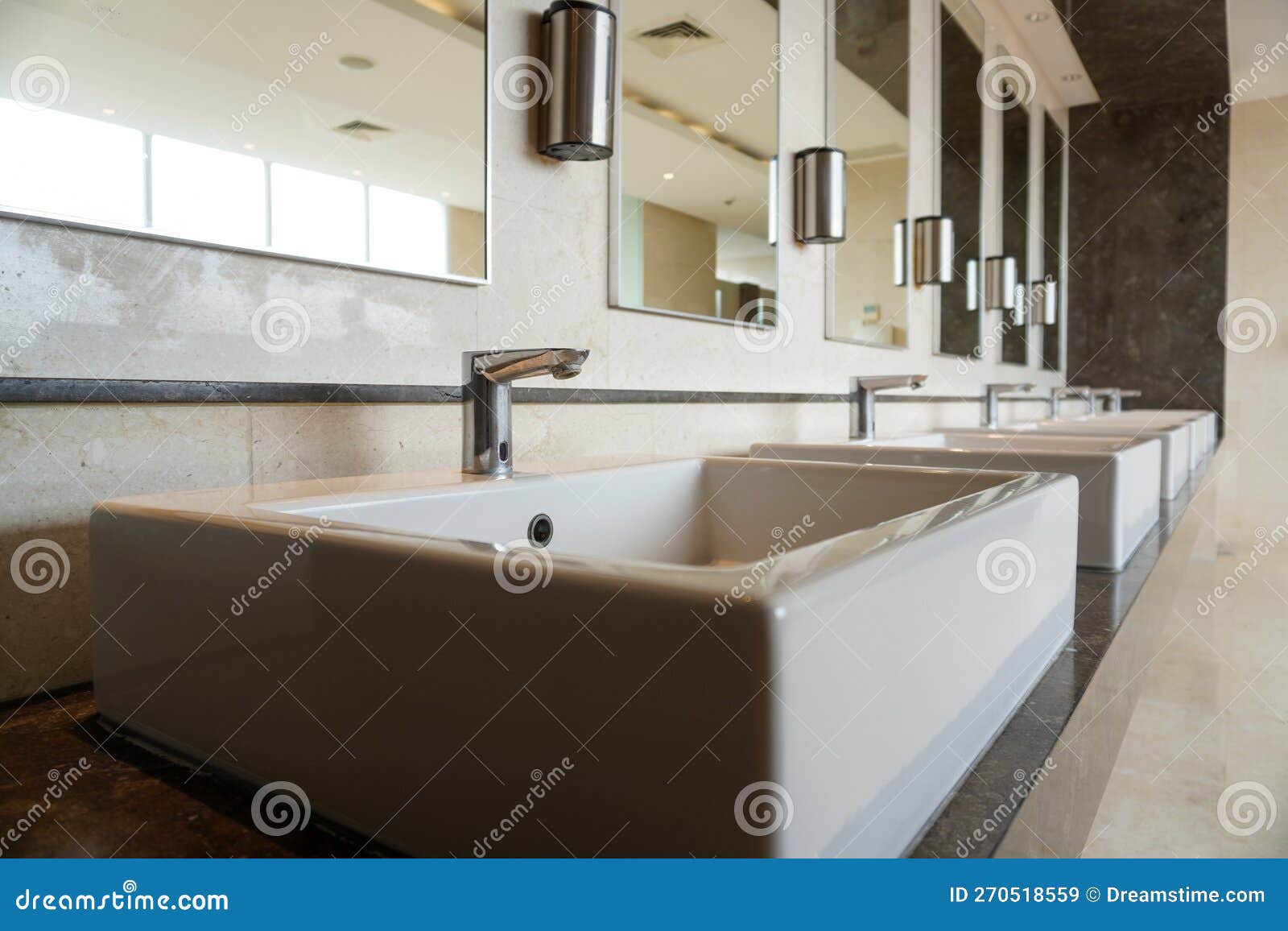 Rows of Sinks in Public Toilets Look Clean and Ready To Use. Stock
