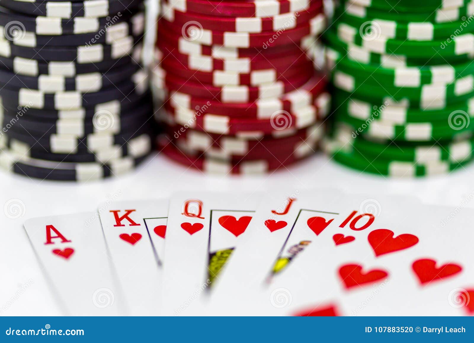 A Royal Flush of Hearts with Blurred Poker Chips in the Background on a