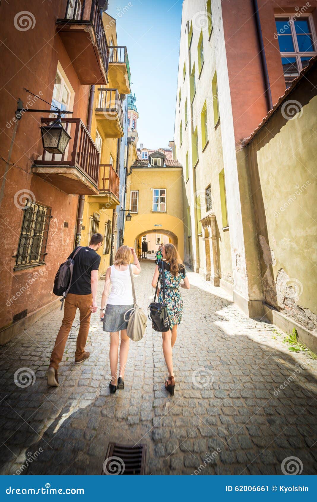 Rua velha da cidade em Varsóvia, Polônia, Europa. Varsóvia, Polônia - 17 de maio de 2013 Povos que andam na rua de pedrinha velha e estreita de Varsóvia, Polônia, Europa Dia ensolarado bonito, construções coloridas Vista do patrimônio mundial do Unesco