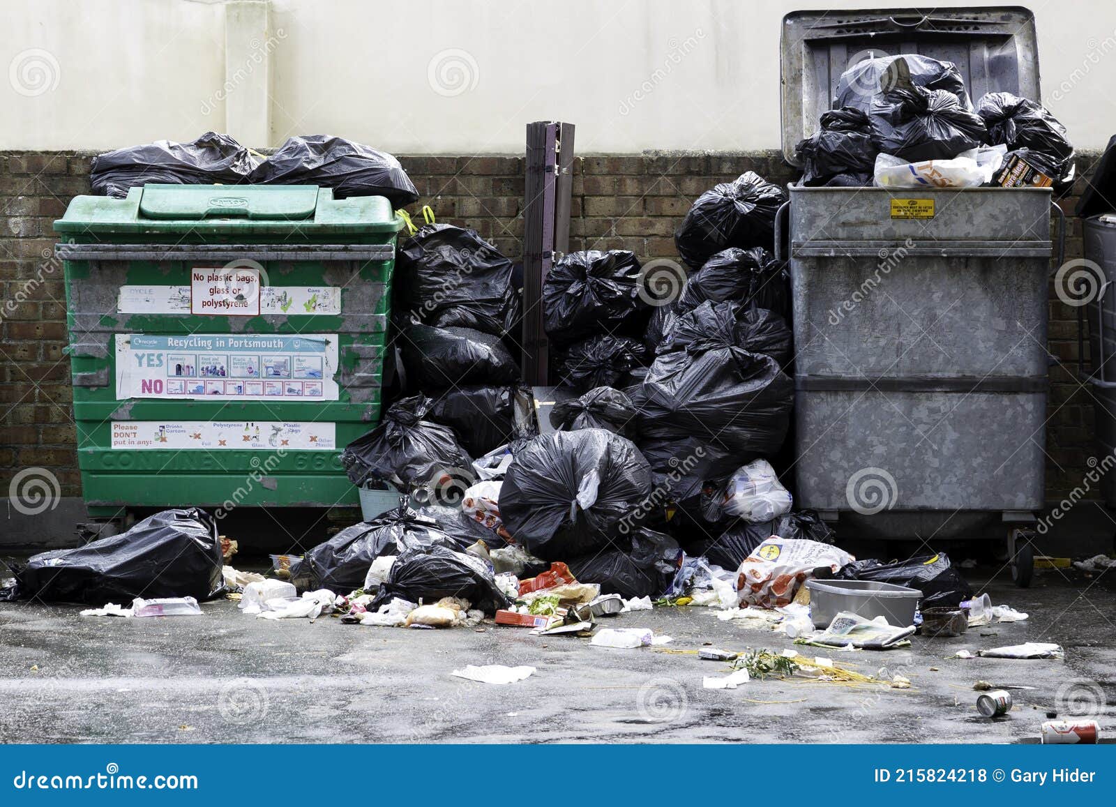 rubbish or garbage bins overflowing with rubbish and rubbish bags with garbage or rubbish all over the street