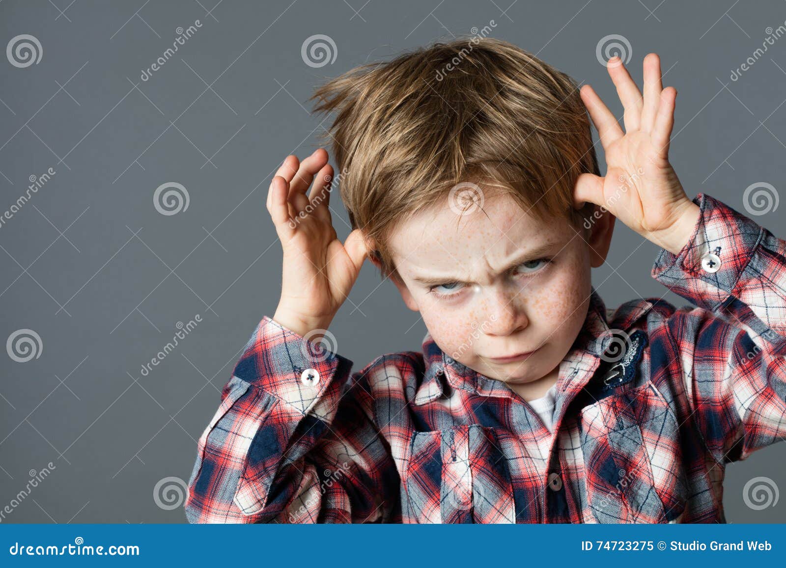 rude kid playing with hands making face for determined attitude