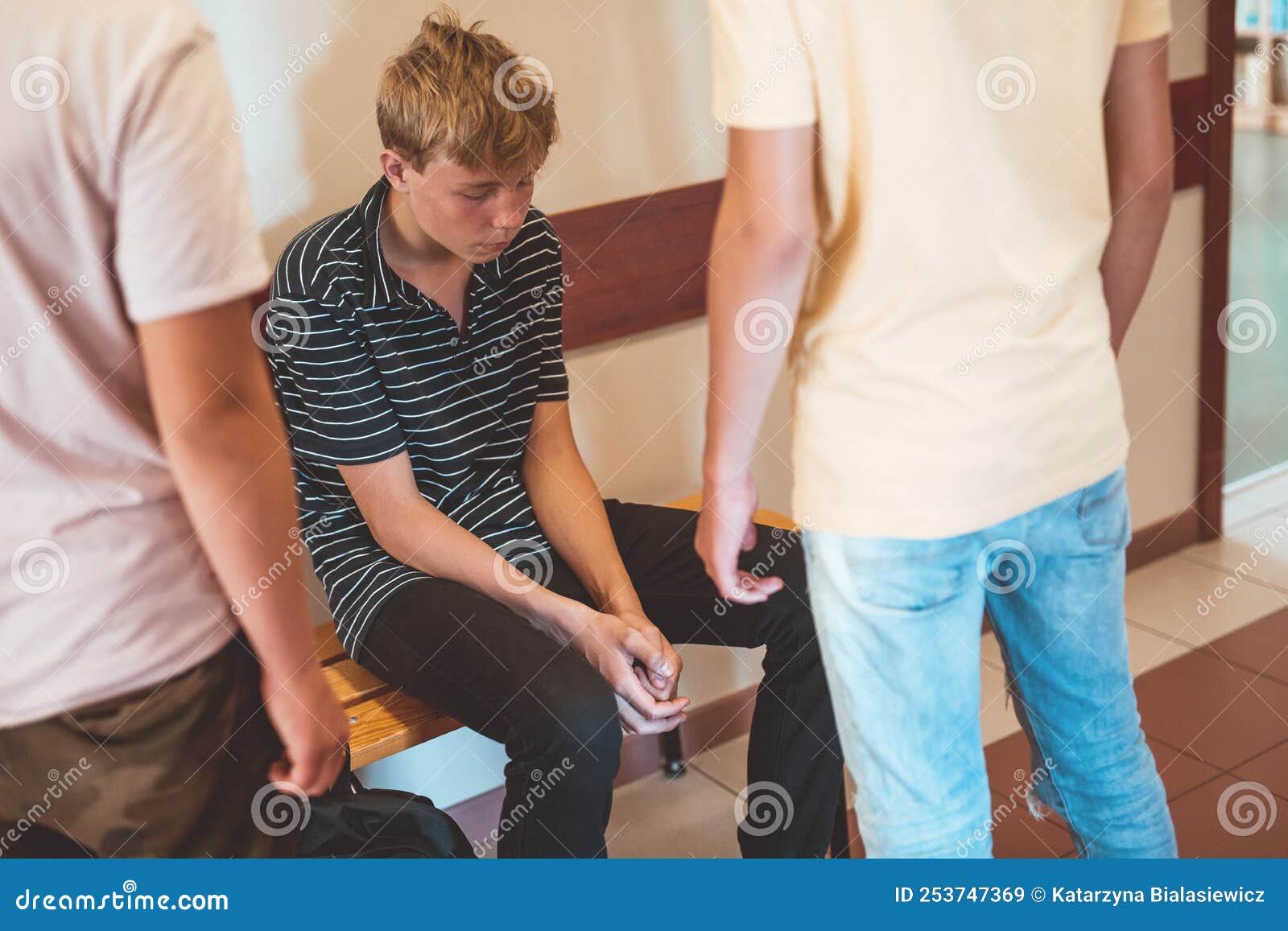 rude teenage ids bulling their poor classmate on the school corridor