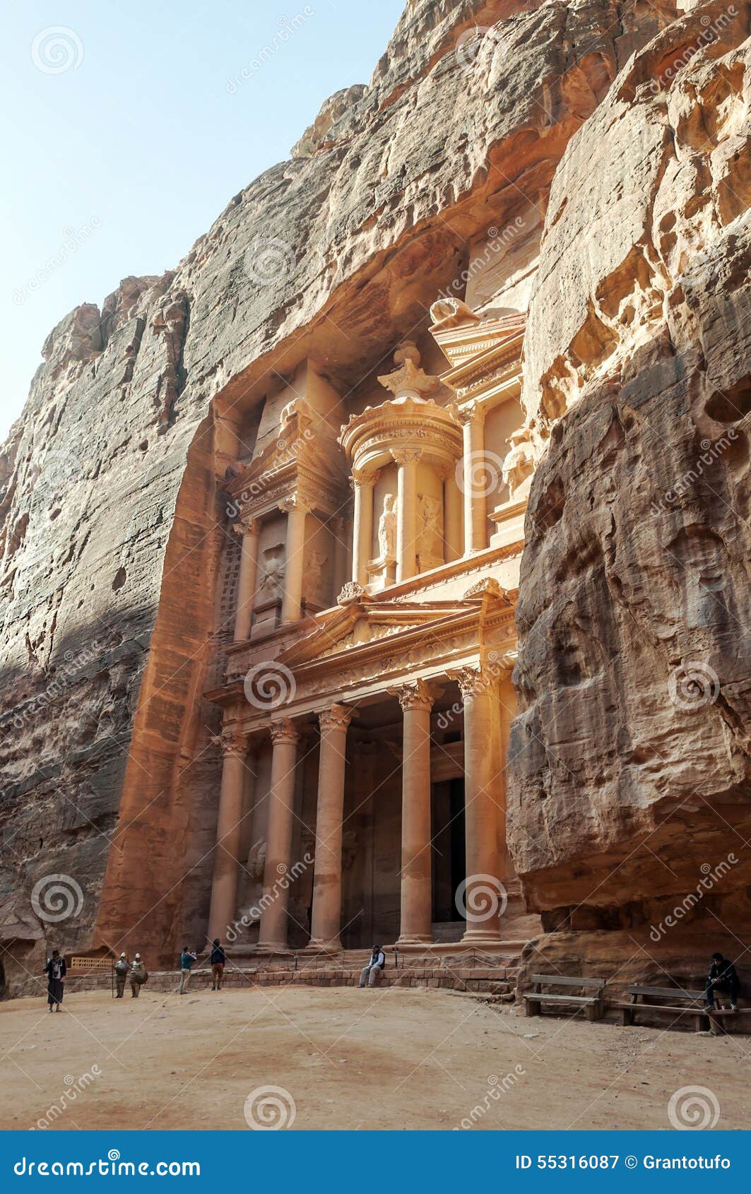 Tourists walking in the ruins of Petra, is an editorial image vertically on a sunny day