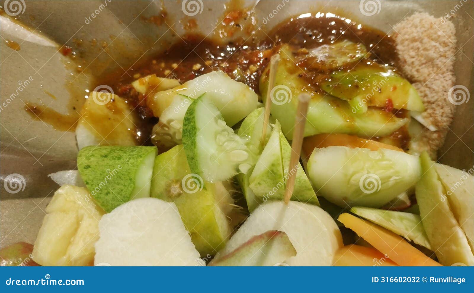 rujak buah or indonesian mixed fruit salad, served with spicy brown sugar sauce and ground peanuts