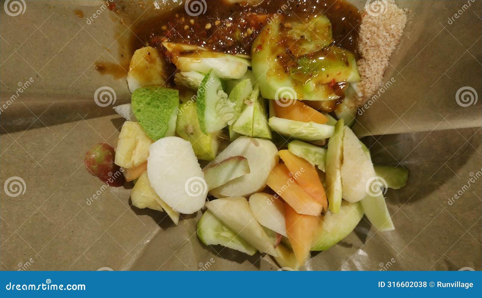 rujak buah or indonesian mixed fruit salad, served with spicy brown sugar sauce and ground peanuts