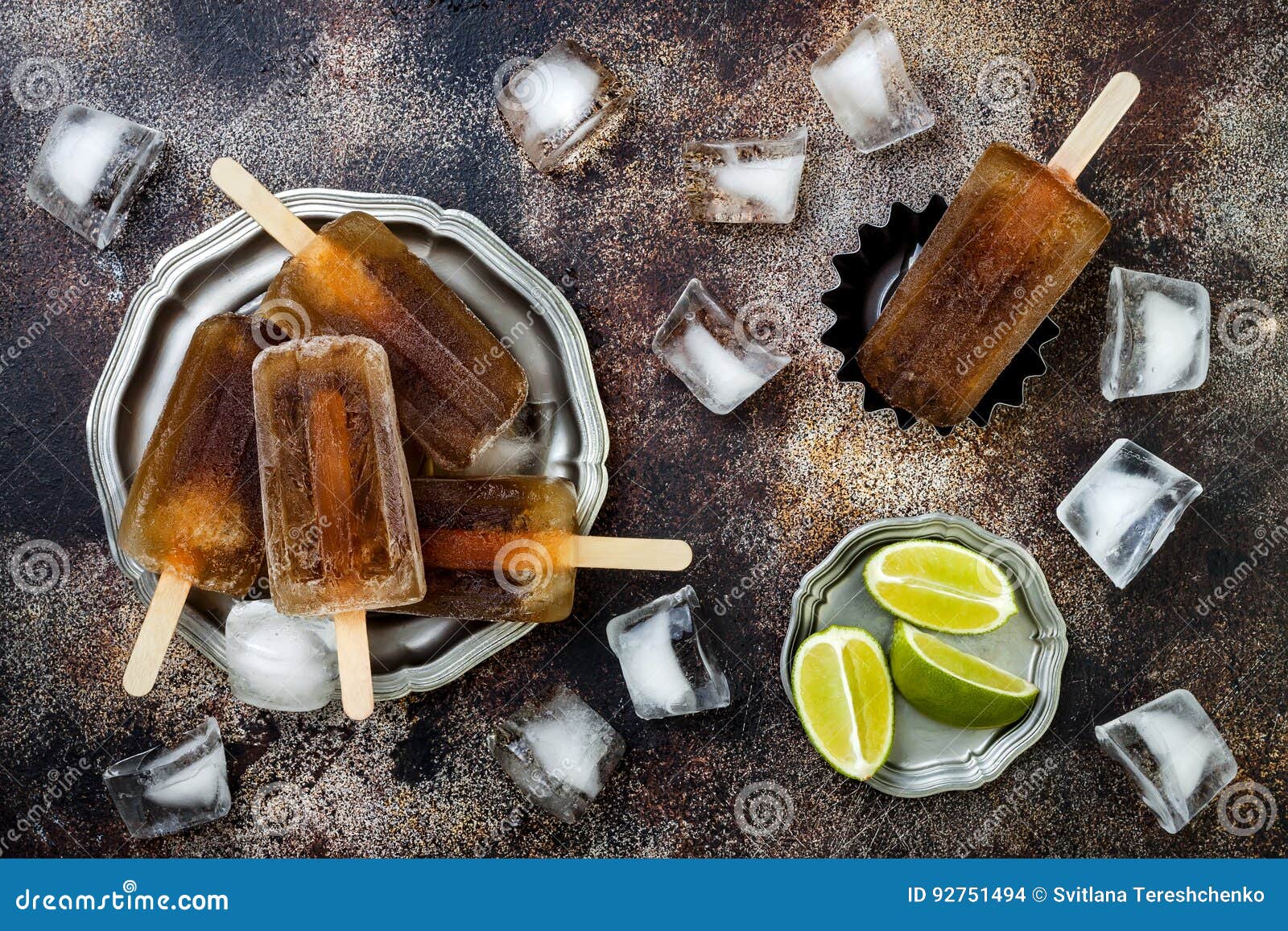 rum and coke cocktail popsicles with lime juice. cuba libre homemade frozen alcoholic paletas - ice pops. overhead, flat lay