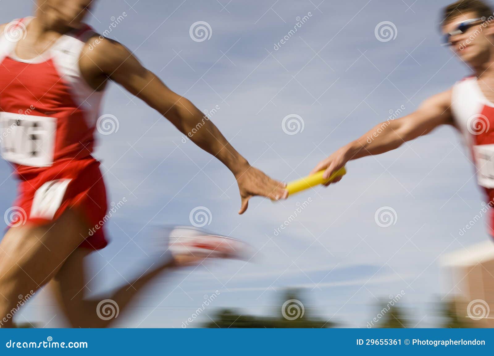 runners passing baton in relay race