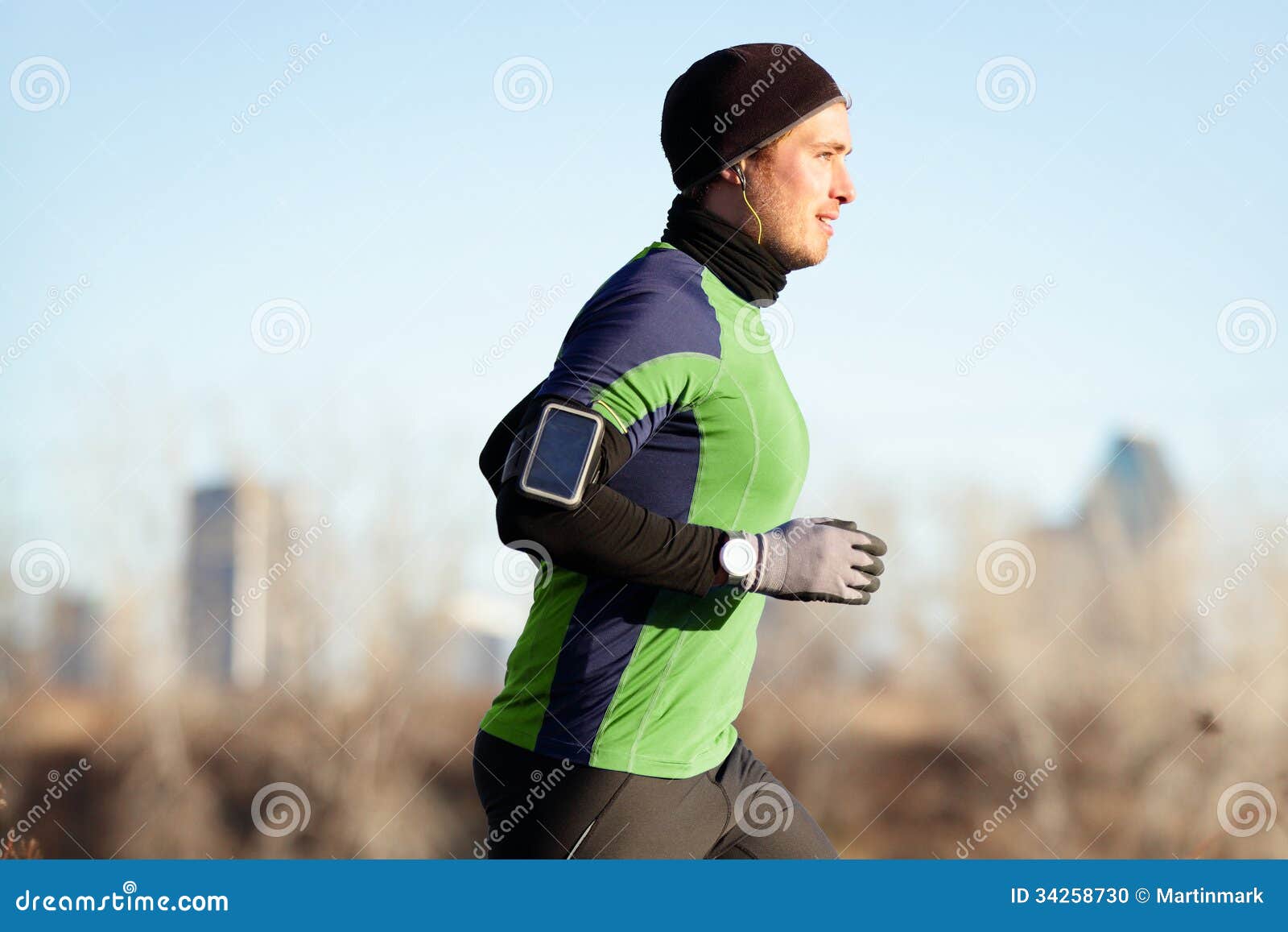 Running Man Jogging In Autumn To Music On Phone Stock Photo
