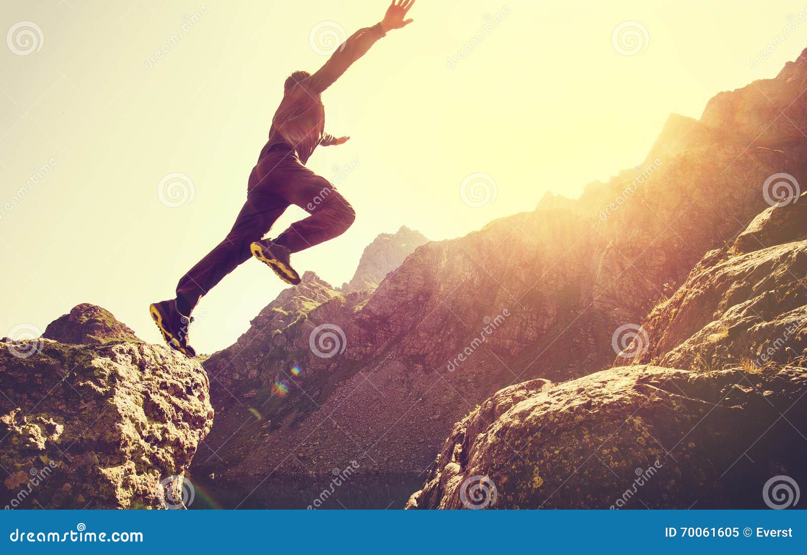 running man on mountains jumping cliff over lake