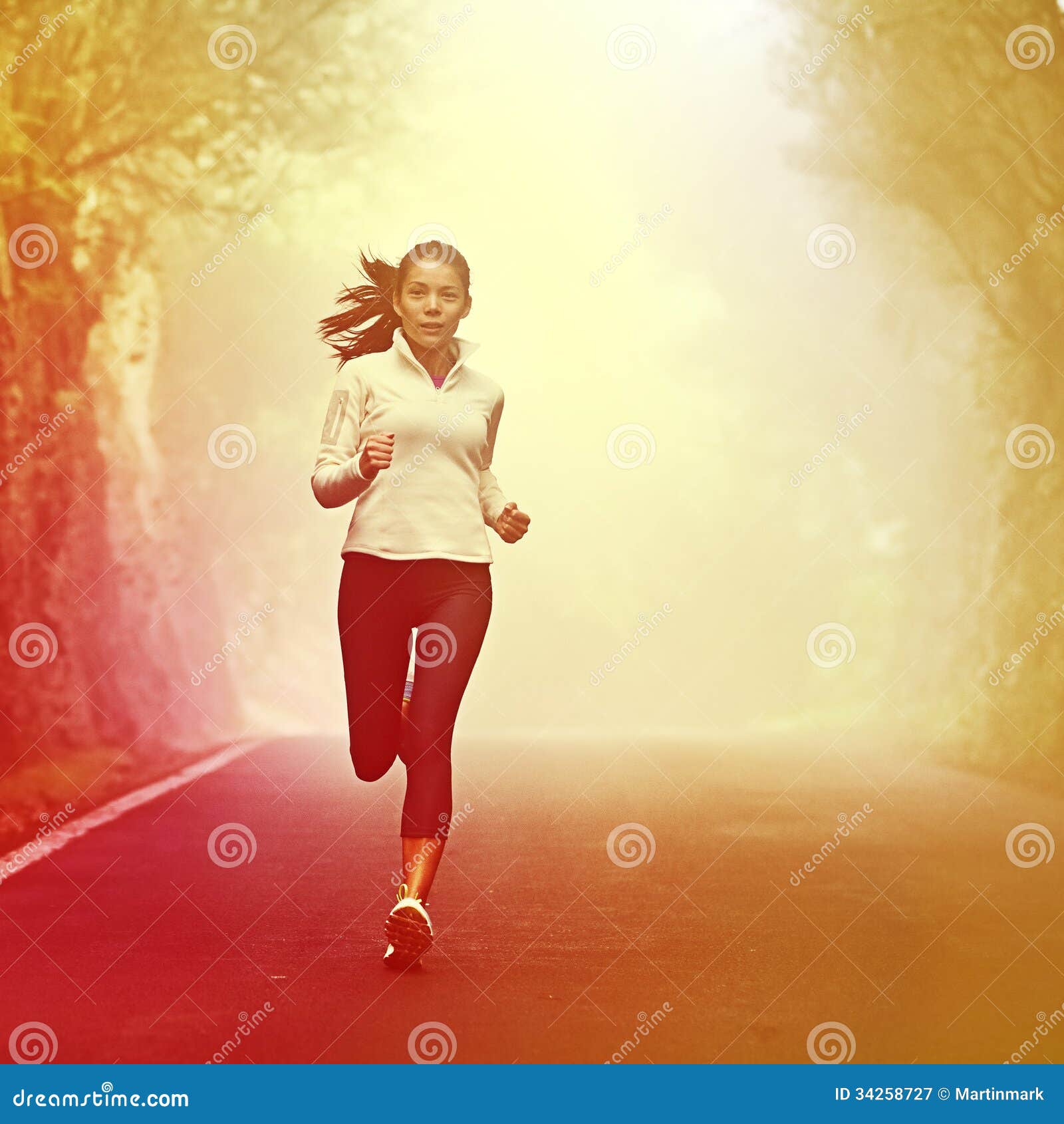 Woman runner in jogging outfit running on a street. Woman