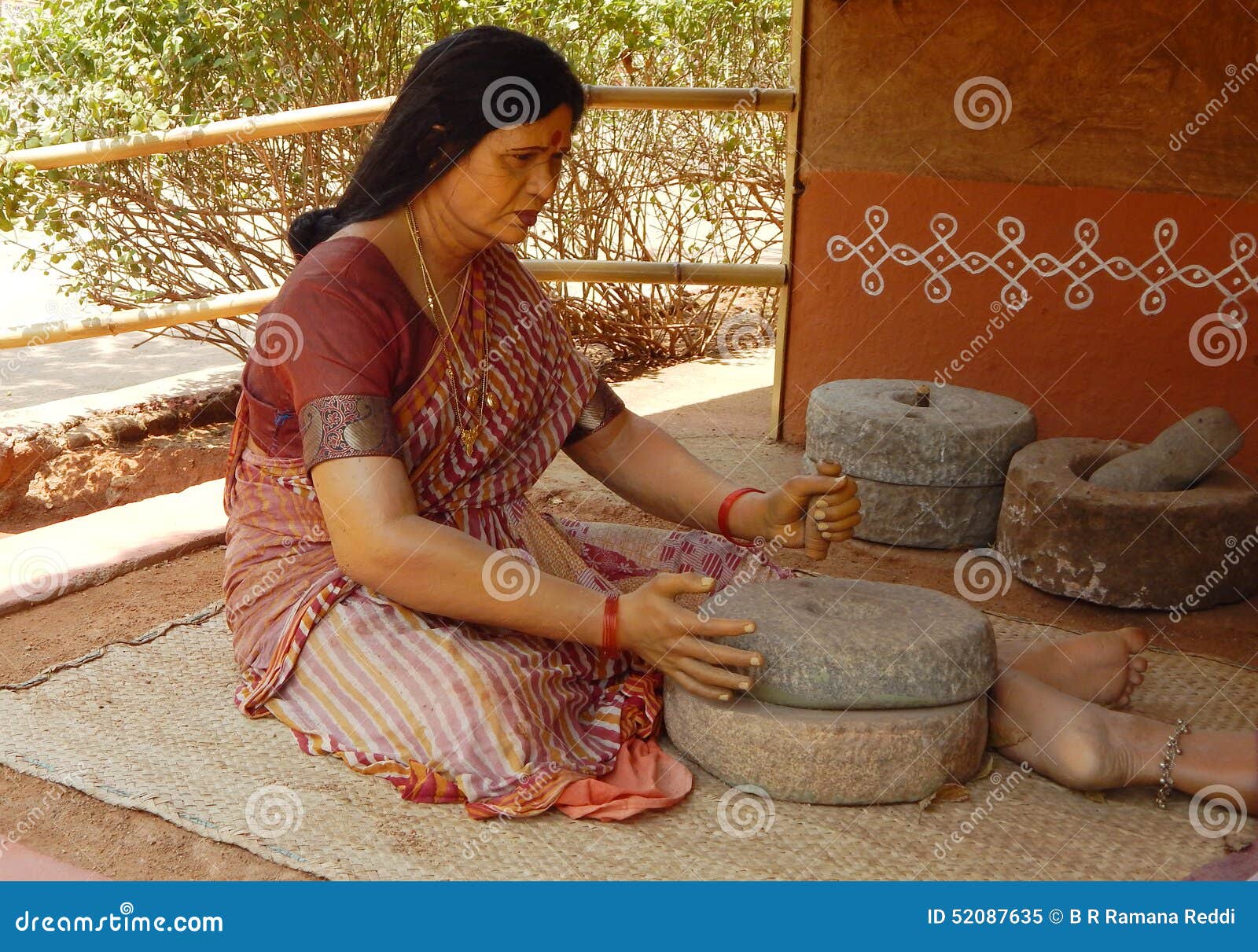 Rural Indian Woman Figure Using Stone Grinder To Make Flour Editorial