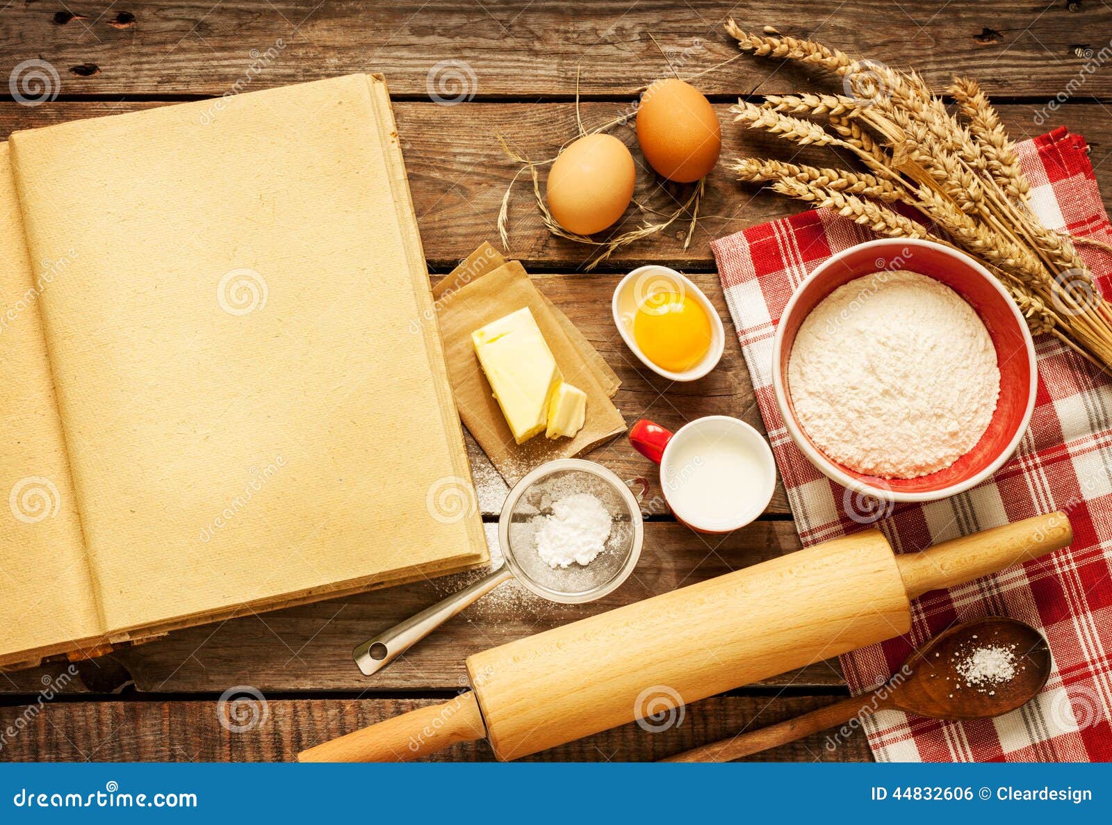 Rural vintage wooden kitchen table with blank cook book, baking cake 