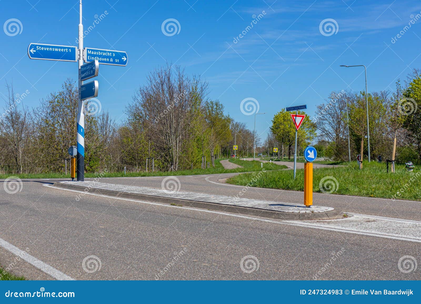 rural road intersection, signs indicating the direction to stevensweert, maasbracht and eindhoven, traffic signs